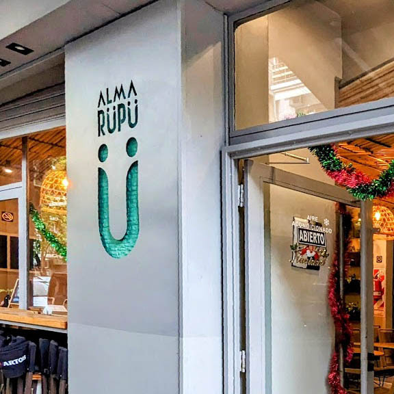 Fachada de ALMA RÜPÜ, donde se ve el cartel luminoso que colocamos como parte de las reformas que realizamos en la cafetería